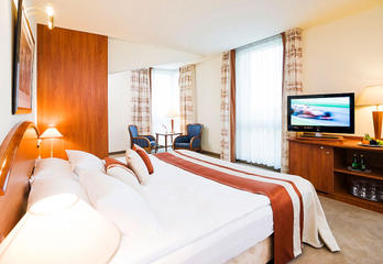 Гостиничный номер в Mercure Poznan Centrum в светлых тонах &mdash; двуспальная кровать, тумба под ТВ, шкаф
