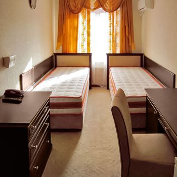 Photo of hotel room with single beds, chest of drawers and dressing table from series of furniture for hotels Karolina